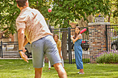 Eltern mit Tochter (12-13) spielen Baseball im Park