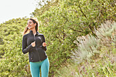 Smiling mid adult woman jogging outdoors\n