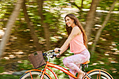Lächelnde junge Frau beim Fahrradfahren im Park