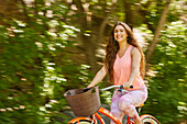 Lächelnde junge Frau beim Fahrradfahren im Park