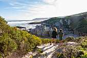 Südafrika, Hermanus, Bruder (10-11) und Schwester (16-17) schauen auf den Atlantik in Voelklip Beach