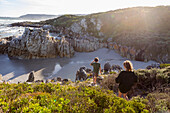 South Africa, Hermanus, Brother (10-11) and sister (16-17) exploring rocky coastline in Voelklip Beach\n