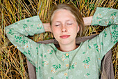 Junge Frau liegend im Feld mit geschlossenen Augen