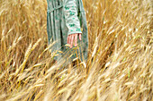 Junge Frau in Kleid steht in einem Weizenfeld