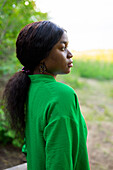 Side view of brunette woman wearing green blouse\n