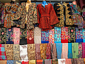 Jacken und bunte Stoffe zum Verkauf in der Stadt Jerash, Jordanien, Naher Osten