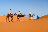 Familie mit einem Kind genießt einen Kamelritt in der Wüste, Erg Chebbi, Merzouga, Sahara-Wüste, Marokko, Nordafrika, Afrika