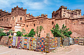 Bunte handgefertigte Teppiche, die vor den alten Ruinen der Kasbah von Telouet zum Verkauf hängen, Hoher Atlas, Marokko, Nordafrika, Afrika