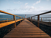 Leuchtturm Farolim dos Fenais da Ajuda mit einem symmetrischen Holzweg, der zu ihm führt, Insel Sao Miguel, Azoren, Portugal, Atlantik, Europa