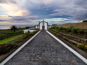 Bewölkter Himmel bei Sonnenuntergang über der kleinen Kirche Ermida de Nossa Senhora do Pranto im Norden der Insel Sao Miguel, Azoren, Portugal, Atlantik, Europa