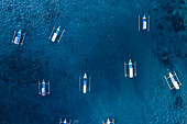 Luftaufnahme von traditionellen leeren Fischerbooten im blauen Wasser von Gili Trawangan, Gili Islands, West Nusa Tenggara, Pazifischer Ozean, Indonesien, Südostasien Asien
