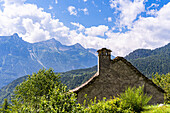 Ein traditionelles Haus im ländlichen Baustil, gebaut aus Bergfelsen in einem schönen Alpental im Sommer, Piemonte (Piemont), Norditalien, Europa