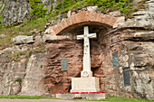 Kriegerdenkmal, das den gekreuzigten Jesus Christus darstellt, zum Gedenken an die Gefallenen des Ersten und Zweiten Weltkriegs, im Dorf Bamburgh, Northumberland, England, Vereinigtes Königreich, Europa