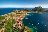 Guadeloupe, Les Saintes, Terre de Haut, the bay of the town of Terre de Haut, listed by UNESCO among the 10 most beautiful bays in the world, Dominica island in background (aerial view)\n