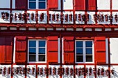 Frankreich, Pyrenees Atlantiques, Baskenland (Frankreich), Espelette, traditionelle Fassade des Baskenlandes mit getrockneten Paprikaschoten