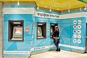 France, Nord, Lille, service area at the Lille Flandres train station, young woman from behind buying a ticket at an ATM\n