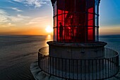 France, Gironde, Verdon-sur-Mer, rocky plateau of Cordouan, lighthouse of Cordouan, classified Historical Monuments, lighthouse keeper at the lantern at sunset (aerial view)\n