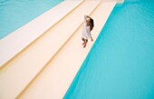 France, Caribbean, Lesser Antilles, Guadeloupe, Grande-Terre, Le Gosier, woman in the middle of the swimming pool of the Créole Beach hotel, aerial view\n