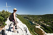 France, Gard, Ardeche Gorges, Aigueze, most beautiful villages of France, Female hiker enjoying th view on the Ardeche river above the village from the Castelviel rock\n
