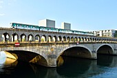 France, Paris, area listed as World Heritage by UNESCO, Bercy district, the pont de Bercy bridge over Seine river and Bibliotheque Nationale de France (National Library of France) by architect Dominique Perrault in the background\n