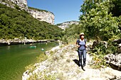 France, Ardeche, Sauze, Ardeche Gorges natural national reserve, Female hiker on the downstream path of the Ardeche Canyon between Gournier bivouac and Sauze\n