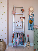 Nursery with clothes ladder, hat and toy guitar on the floor