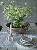 Set wooden table with candle holder, bowls and flower vase arrangement