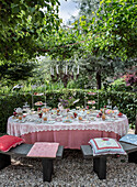 Coffee table in the garden with richly laid table and chandelier