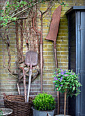 Rustic garden tools on brick wall