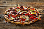Kartoffelteig-Pizza mit Tapenade, Pulpo, Chorizo und Zucchini