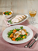 Roast turkey cutlet with peas and carrots