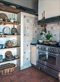 Country kitchen with patterned tiles and open wooden shelves