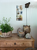 Natural wood dresser with rustic clay pots and potted plant