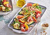 Grilled zucchini salad with prosciutto and peaches