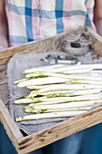 White asparagus spears in a wooden crate