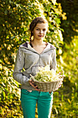 Girl holding basket with elderflowers