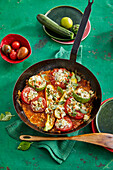 Stewed tomatoes and zucchini with feta and pine nuts