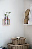 Corner with wooden artwork, dried flowers and storage boxes made from recycled material