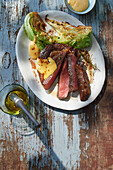 Grilled rib-eye steak in a gin and rosemary marinade with pointed cabbage