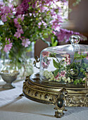 Baroque serving platter with glass dome and floral arrangement