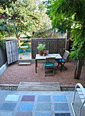 Shady patio area with table and chairs