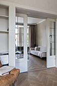 View into a bright living room with parquet flooring and glazed sliding doors