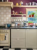 Classic kitchen with purple walls, grey cabinets and black and white checkerboard floor