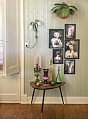 Retro-style table with colorful bottles and surreal art prints on wall with wallpaper