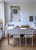 Dining area with white bench, wooden table and chairs