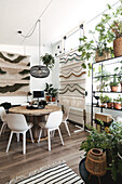 Dining area with lots of houseplants and boho-style tapestry