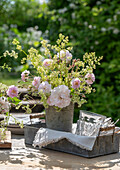 Weisse Rose 'Stanwell Perpetual' (Rosa) als Strauß mit Wiesenlabkraut (Galium mollugo) in altem Zinkeimer auf der Terrasse