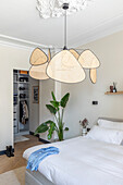 Modern bedroom with large pendant lamp and walk-in wardrobe