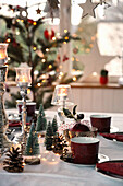 Christmas table setting with red coffee crockery and fir trees