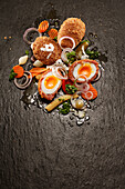 Scotch eggs with carrots, baby corn and red onions